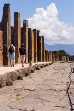 Pompei, İtalya için iki turist ile antik ören sokak. İtalyan antik kenti antik yol. Pompeii landmark. Tarih ve mimari konsepti. 