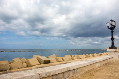 Bulutlu gün demir sokak fenerle taş sahil. Adriyatik deniz manzarası. İtalyan panoramik kıyı şeridi. İtalyan Güney arka plan. Sokak dekorasyon İtalya'nın Bari. Seyahat ve tatil kavramı. 