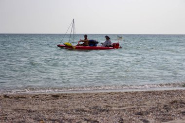 İki bilinmeyen erkekler kauçuk gemiler ve deniz kıyısı yelken Ukrayna bayrağı ile tekne. Tatil ve eğlence kavramı. Kauçuk balıkçı tekne. Yaz dinlenmek.  