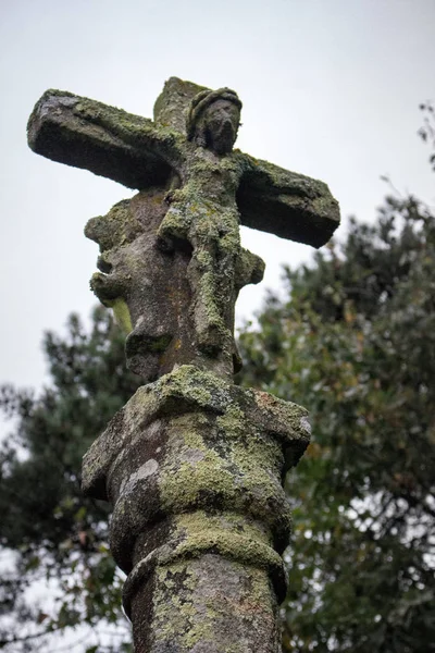 Ancient stone statue with ruined jesus christ figure. Medieval religious sculpture. Old cross with jesus figure. Faith and religion concept. Religious architecture.