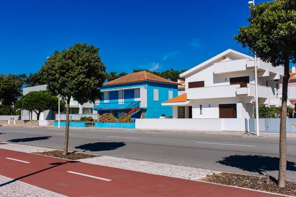 Esposende, Portugal - 10/03/2018: modern villas on sunny day. Traditional portuguese buildings with close shutters. Empty street on hot summer day. Daily siesta concept. Outdoor houses design.