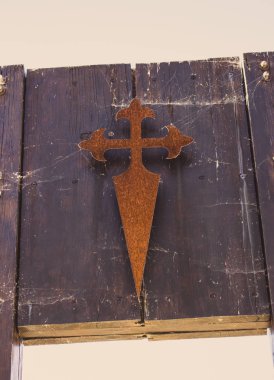 Eski metal Santigo net ile ahşap kalas üzerinde çapraz. Camino de Santiago, İspanya'da kızıl haç. Hac ve seyahat konsepti. Manevi yol kavramı. Hacıların antik sembolü. Santiago de Compostela şekilde Vintage çapraz. 