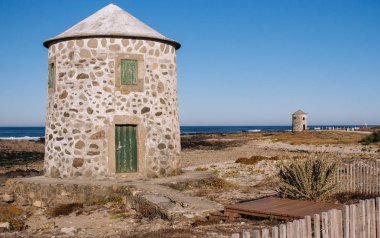 Atlantik Okyanusu kıyısında iki taş terk edilmiş deniz feneri. Ortaçağ Avrupa mimarisi. Eski navigasyon konsepti. Camino de Santiago yolu üzerinde yuvarlak deniz fenerleri, Portekiz. Tarihi binalar. Seyahat ve turizm konsepti.