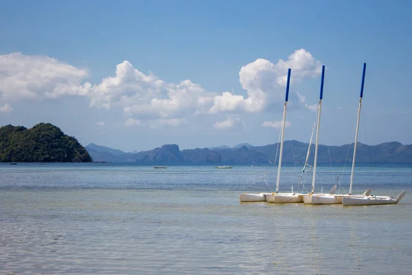 熱帯海 フィリピンの4つの白いヨット 地平線上のボートや山と風光明媚な熱帯の風景 夏休みと旅行 アジアの牧歌的なラグーン 晴れた日の熱帯の楽園 — ストック写真