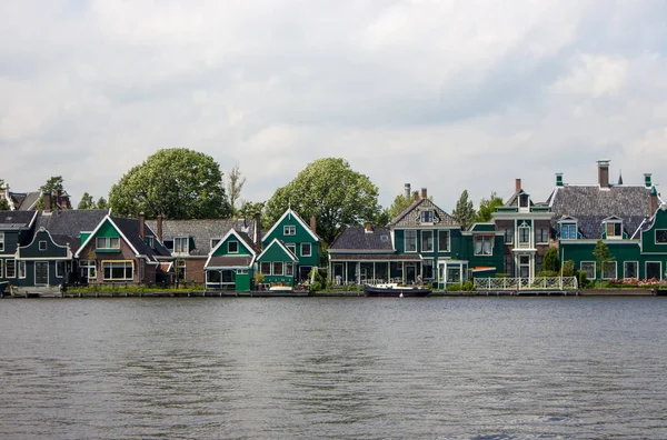 Typical dutch buildings on the river side. Holland architecture. Country houses in Zaanse Schans, Netherlands. Rural buildings on the lake. Summer travel concept. Summer countryside view.