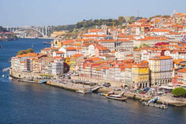 Porto ve tekneler dolgu ile Douro Nehri. Güneşli bir günde Porto panoramik dönüm noktası. Porto, Portekiz Douro nehri tarafından tuğla çatılı eski binalar. Porto'nun tarihi bölgesi. Portekiz cerebu.