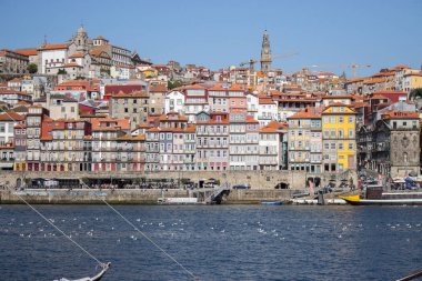 Porto renkli dolgu ile River Douro. Güneşli bir günde tekneler ile Porto panoramik dönüm noktası. Porto, Portekiz Douro nehri tarafından tuğla çatılı eski binalar. Porto'nun tarihi bölgesi. Portekiz cerebu.