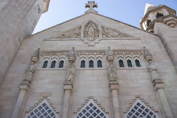 Haç ve heykelleri ile beyaz taş katedral. Katolik Katedrali'nin mimari detayları. Katolik Kilisesi'nin cephesi. Din ve inanç kavramı. Din turizmi kavramı.
