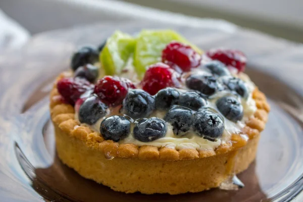 Tasty cake with fresh berries close up. Homemade tart with blueberries, raspberries and kiwi slices. Delicious dessert. Sweet breakfast concept. Pie with fruits and berries. Bakery concept.