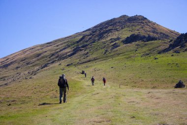 Fransa 'nın Pyrenees dağlarındaki bir grup hacı. Dağlarda yürüyüş. Napolyon rotası. Roncesvalles vadisinde turistler. Hac konsepti. Camino de Santiago yolu. Yazın manzaralı dağ manzarası. 