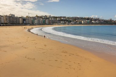 Biscay Körfezi 'nin geniş plajı. San Sebastian tarihi, Bask Bölgesi, İspanya. Arka planda turistlerin ve evlerin olduğu sahile..