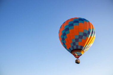 Kyiv, Ukrayna - 06 / 26 / 2020: Açık yaz gökyüzünde sıcak hava balonu. Mavi arka planda renkli bir balon. Parlak geometrik tasarım. Yaz macerası ve boş zaman. Havacılık sporu konsepti.