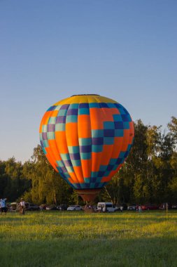 Kyiv, Ukrayna - 06 / 26 / 2020: Başlamadan önce sıcak hava balonunun hazırlanması. Yerde kocaman renkli bir balon vardı. Parlak geometrik tasarım. Yaz macerası ve boş zaman. Balon festivali. 