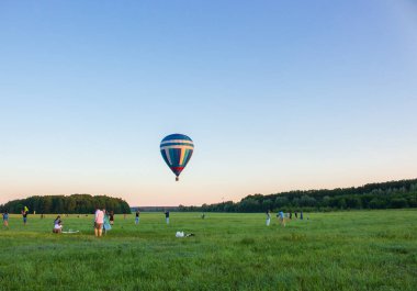 Kyiv, Ukrayna - 06 / 26 / 2020: İnsanlarla açık havada sıcak hava balonu. Hava manzarası arka planında renkli bir balon. Yaz tatili. Sıcak hava balonu sabah uçuyor..