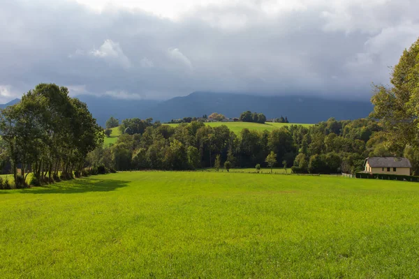 山中的夏日风景 美丽的草坪和山上的房子 郊区的风景 阳光下的田野 云中的群山 牧场和村庄 美丽的山谷山上的农场 — 图库照片
