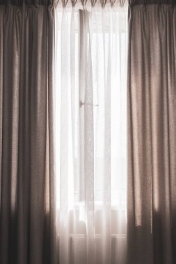 Perdeli pencere, dikey. Daire tasarımı. Açık pencereli gri perdeler. İç mekan. Modern ev dekorasyonu. Pencereyi güneş ışığıyla aç. 