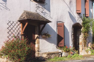 Köydeki eski taş ev. Pencere panjurları, kapısı ve bahçesi olan ortaçağ binası. Antik evlerin arka bahçesi. Geleneksel Fransız evinin dışı. Avrupa 'da tatil. Ortaçağ mimarisi.
