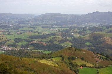 Dağ vadisindeki köy ve yol. Pireneler, İHA 'nın görüntüsü. Camino de Santiago manzarası. Hill Valley 'deki manzaralı çayırlar ve tarım arazileri. Fransa 'nın kırsalında. Seyahat ve macera.