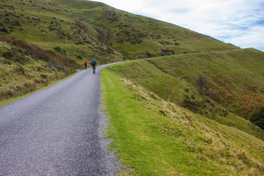Pyrenees 'deki Camino de Santiago' daki hacılar. Manzaralı dağlarda gezginler. Tepelerde kırsal bir yol var. Seyahat ve yürüyüş konsepti. Aktif yaşam tarzı. Hac kavramı.