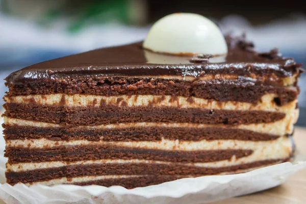 Chocolate layer cake. Biscuit cake with melted ganache on top. Slice of creamy tart. Vanilla and cacao layer dessert. Sweet food concept. Birthday cake close up.