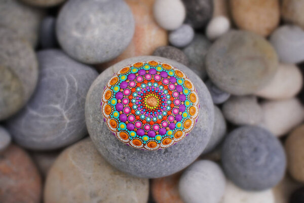 Beautiful mandala hand painted on a sea stone