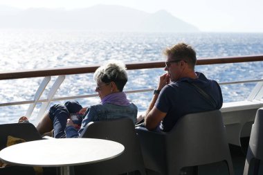 Ios, Yunanistan, 18 Eylül 2018, Kiklad Adaları'nda tipik bir denize hayran kalarak dinlenen bir çift turist