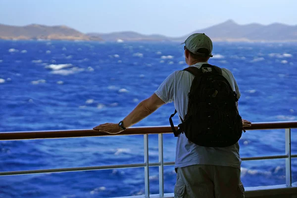 IOS, GRECIA, 18 SEPTIEMBRE 2018, Un turista admira una típica vista al mar y acantilados en las Cícladas — Foto de Stock