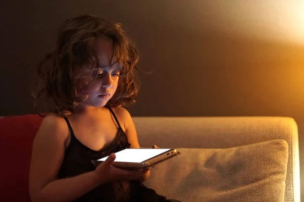 3-4 årig flicka använder mobiltelefon på natten — Stockfoto