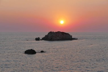 Prasoudi 'de gün batımı, bir meyhanenin balkonundan görünen korfu.