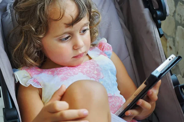 Liten flicka 3 år gammal med en mobiltelefon. — Stockfoto