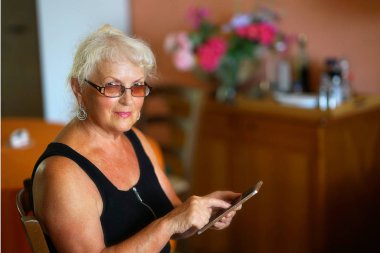 Cep telefonlu yaşlı kadın.