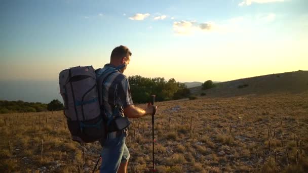 Man hiker walk on mountain hike travel peak with black sea bakground. Spbd tourist climb in crimea during sunset — Stock Footage Man hiker walk on mountain hike travel peak with black sea bakground. Spbd tourist climb in crimea during sunset Video Clip