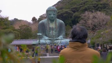 Kamakura içinde büyük Buda heykeli ile ilgilenen insanlar