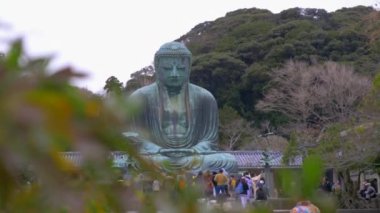Kamakura içinde büyük Buda heykeli ile ilgilenen insanlar