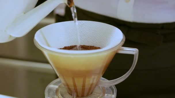 Gros plan de la femme versant de l'eau chaude sur les moulins à café 