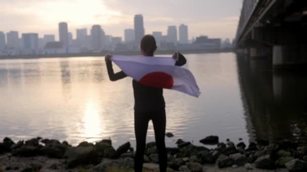 Sorrindo Mulher Com Bandeira Japonesa Orgulhosamente Drapeado Sobre Seus Ombros — Vídeo de Stock