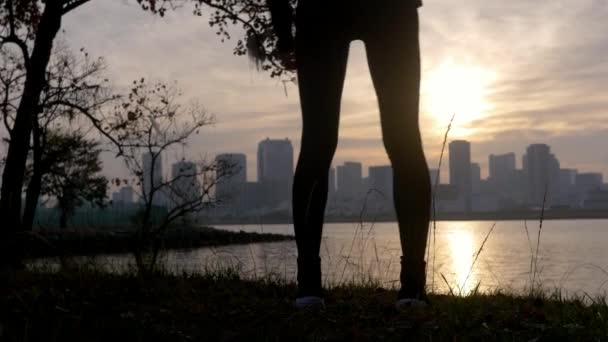 Una Corredora Calentándose Fuera Una Ciudad Silueta — Vídeo de stock