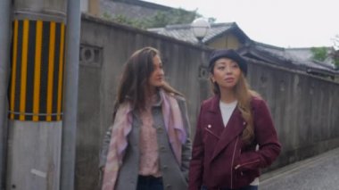 Yürüyüş ve sohbet sırasında işaret eden kadınlar.