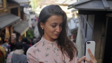 4k İtalyan kadın selifie Kyoto meşgul yürüme sokak arkasında alarak.