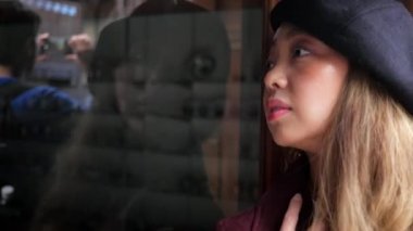 4 k güzel Japon kadın bir pencere reflextion arıyor.