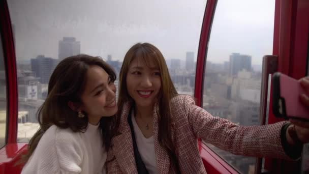 Two Beautiful Friends Talking Pictures Together Riding Large Ferris Wheel — Stock Video