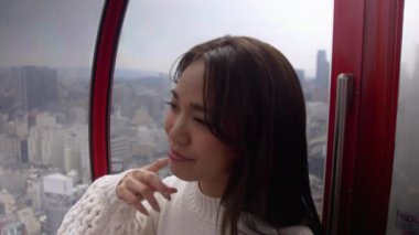 Güzel kadın büyük bir dönme dolaba Osaka, 4k bakarak yüksek