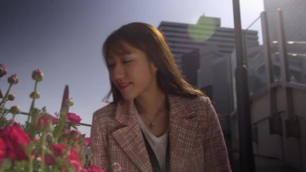 Attraktiv japansk kvinna som luktar nya vår blommor, 4k — Stockvideo