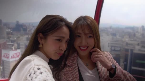 Lindas mujeres japonesas por encima de la ciudad de Osaka tomando fotos juntas, 4K — Vídeo de stock gratis