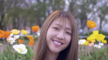 Bahar aylarında bir lale bahçesinin önünde Japon kadınların güzel portresi, 4k