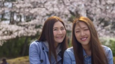İki güzel Japon arkadaşlar gülümseyen kiraz çiçeği sezonu, 4k zevk