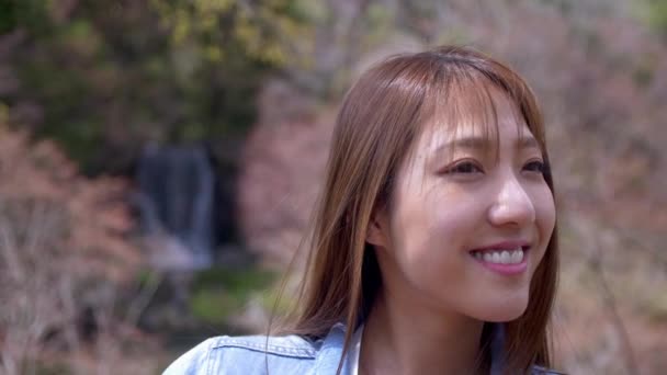 Крупний план привабливою японської жінки на водоспад в парку, повільний рух. — стокове відео