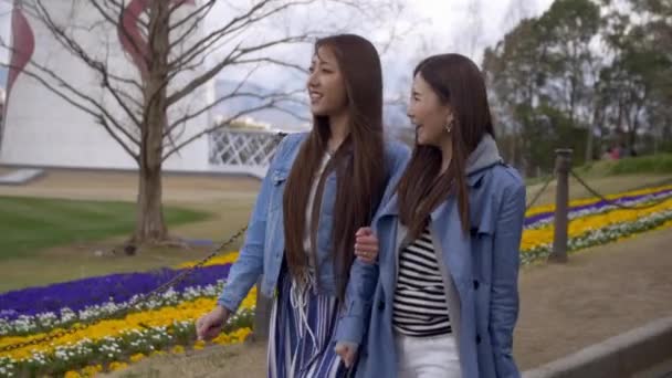 Женщины ходят через красивый цветочный парк весной, Slow-Motion .