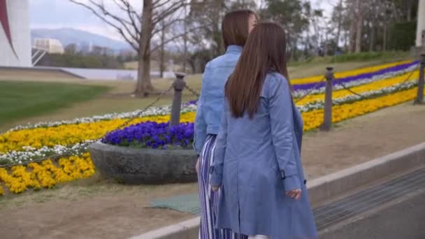 Atractivas mujeres caminando en el parque de flores, cámara lenta . — Vídeo de stock