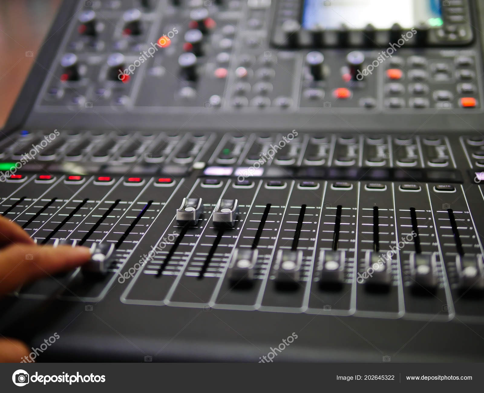 Soft Focus Hand Adjusting Professional Digital Audio Mixer Controller In The Control Room Sound For Live Music And Studio Equipment Soft Focus Hand Adjusting Professional Digital Audio Mixer Controller In The Control Room Sound For Live Music And Studio Equipment